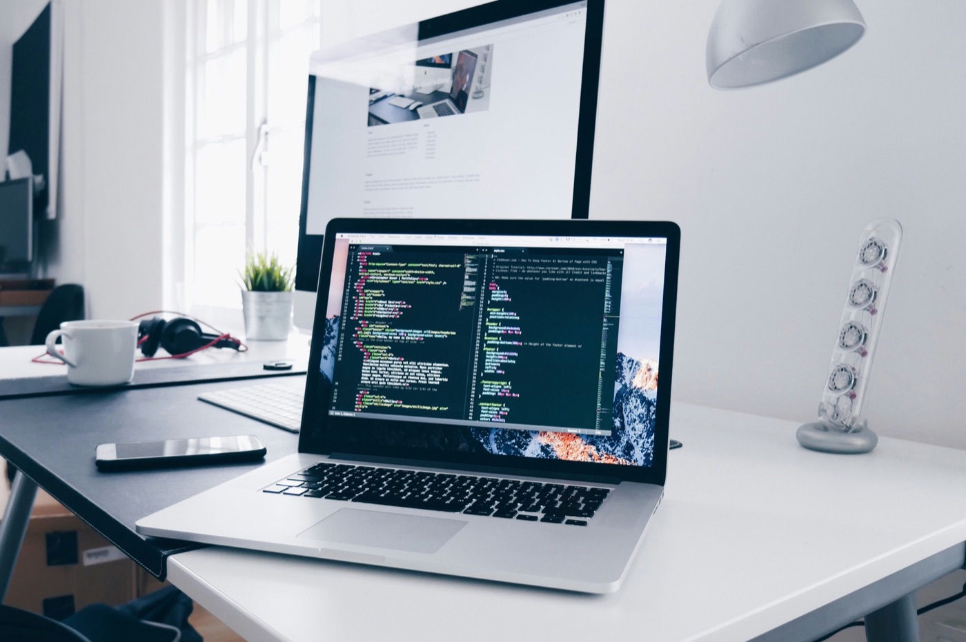 Bright workspace with laptop showing code