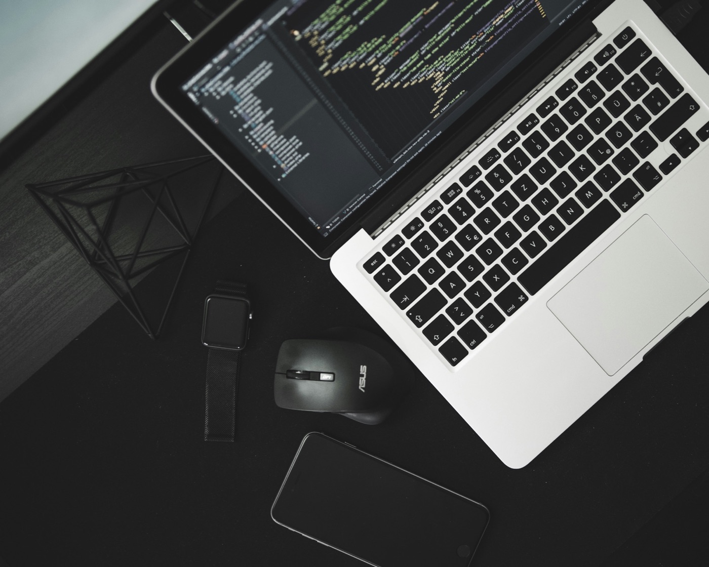 Dark development workstation with laptop and code editor